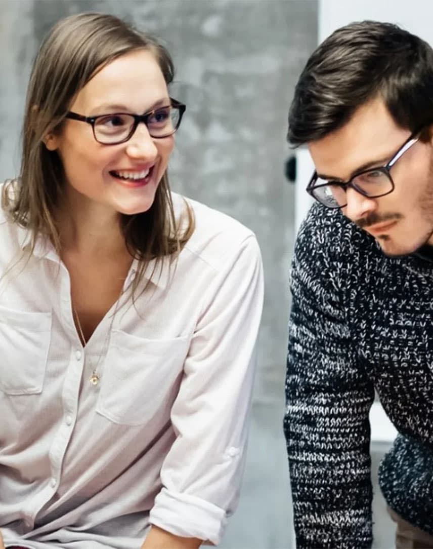 Junge Leute, die sich bei der Arbeit angeregt über ein Thema unterhalten.