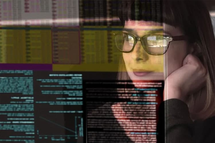 Eine Frau guckt auf einen Bildschirm mit vielen Zahlen