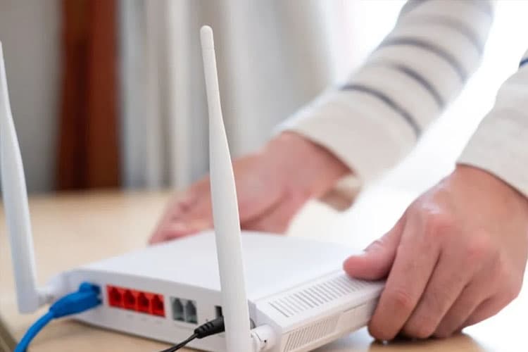 Ein WLAN-Gerät, das von zwei Händen hingestellt wird