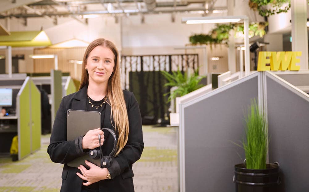 Eine Servicemitarbeiterin von EWE mit Unterlagen in einem Büro