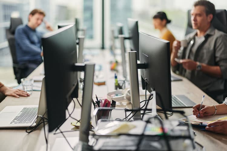KollegInnen an Arbeitsplätzen in einem Büro