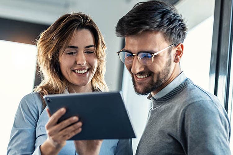 Mann und Frau schauen auf ein Tablet