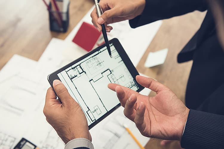 Tablet mit Raumplan in zwei Händen