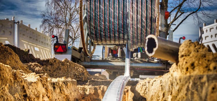 Eine Baustelle, auf der aus einer Kabeltrommel Glasfaser verlegt wird