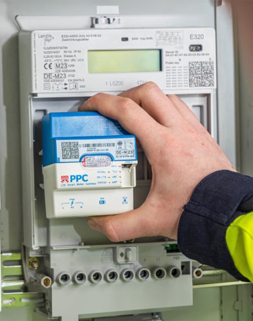 Ein Techniker baut ein intelligentes Messsystem in einen Sicherungskasten ein.