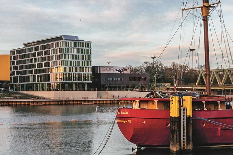 Ein Schiff vor Anker an der Weser, im Hintergrund Gebäude