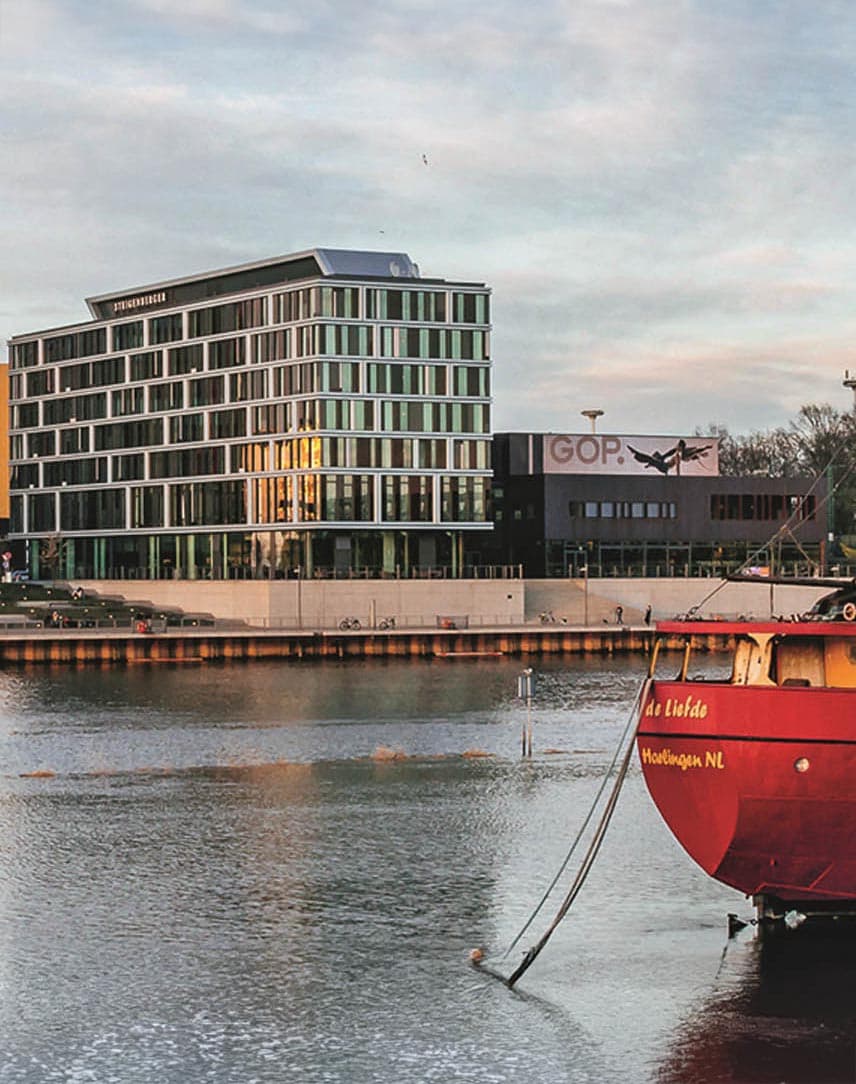 Ein Schiff vor Anker an der Weser, im Hintergrund Gebäude