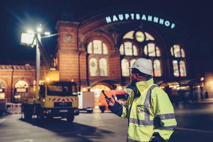 Ein Mitarbeiter von swb, der vor dem Hauptbahnhof an einer Straßenbeleuchtung arbeitet