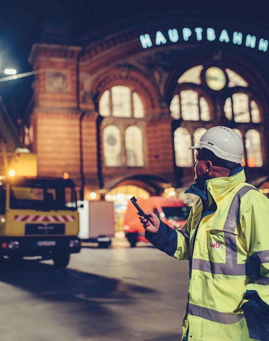 Ein Mitarbeiter von swb, der vor dem Hauptbahnhof an einer Straßenbeleuchtung arbeitet