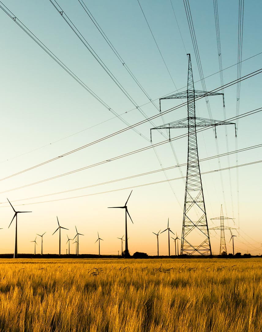 Ein weites Feld mit Strommasten und Windkrafträdern