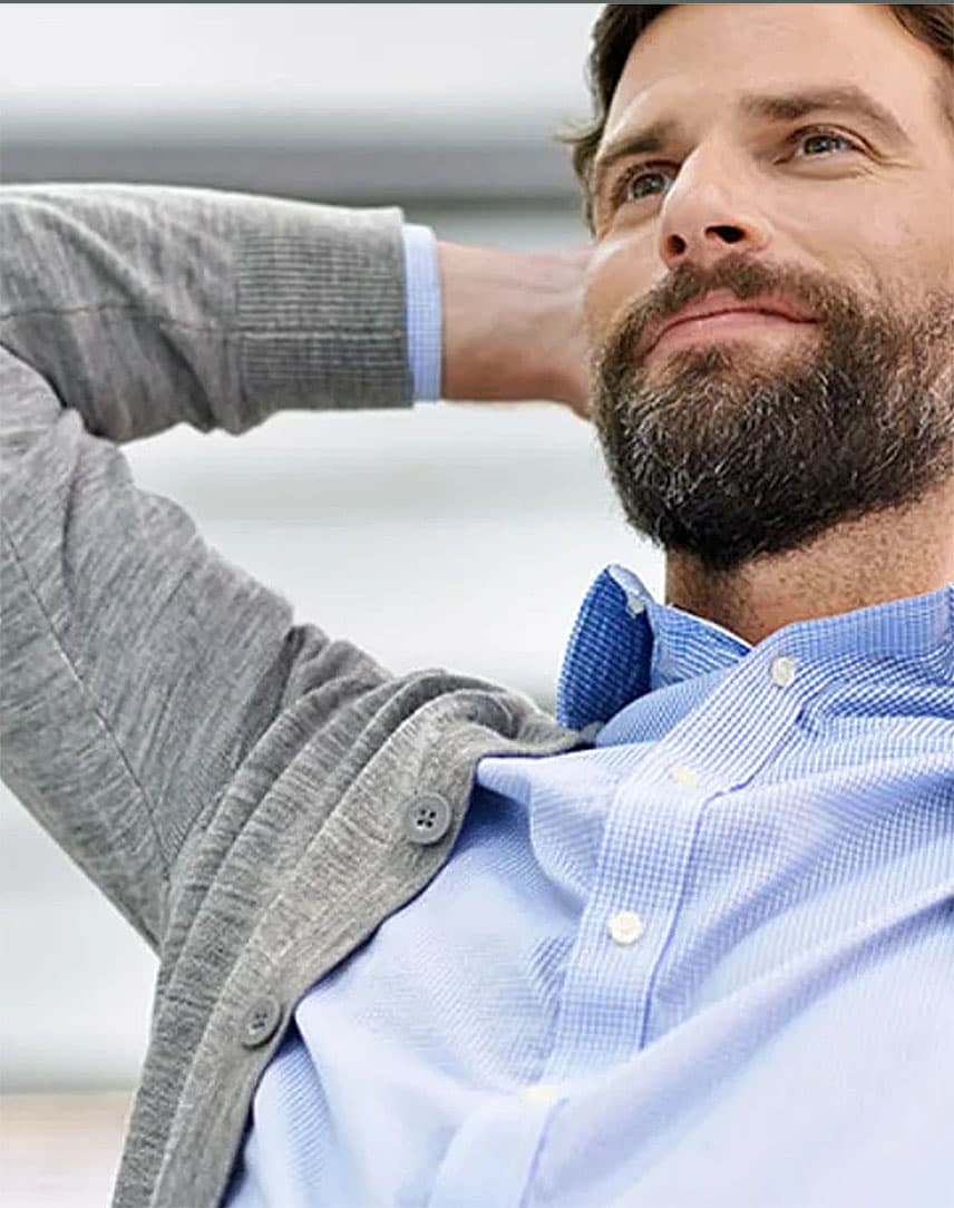 Mann vor Laptop lehnt sich entspannt zurück.