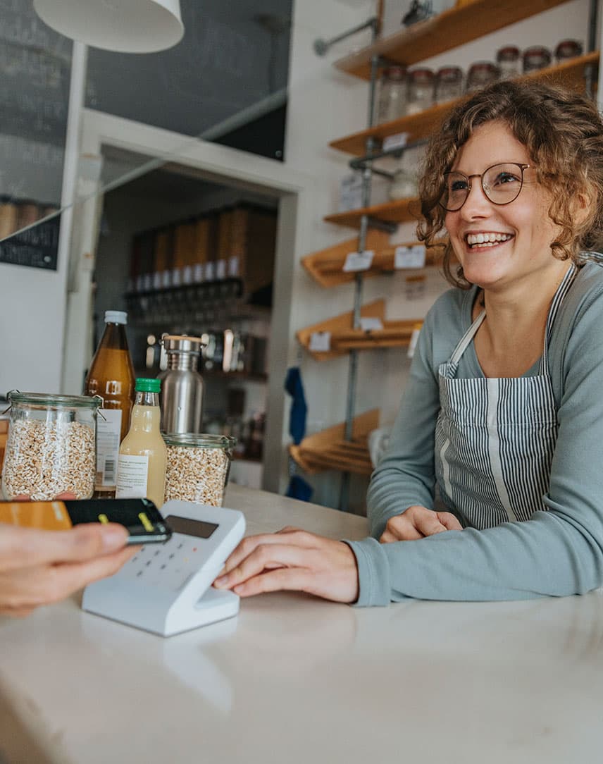 Ein Frau in einem kleinen Laden bedient einen Kunden