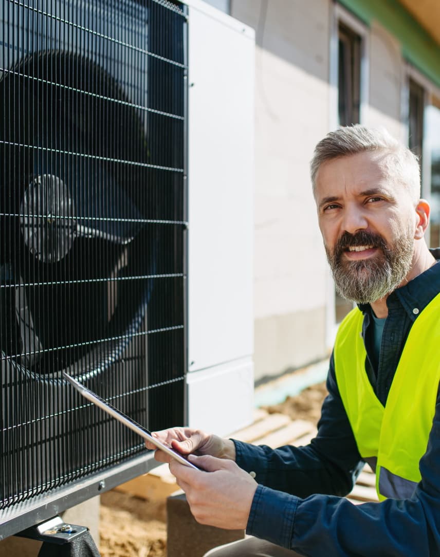 Techniker prüft eine Wärmepumpe für ein großes Neubauprojekt
