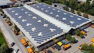 Eine Firmenhalle mit PV-Modulen aus der Luft