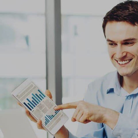 Zwei Männer in einem Büro freuen sich über eine Grafik.
