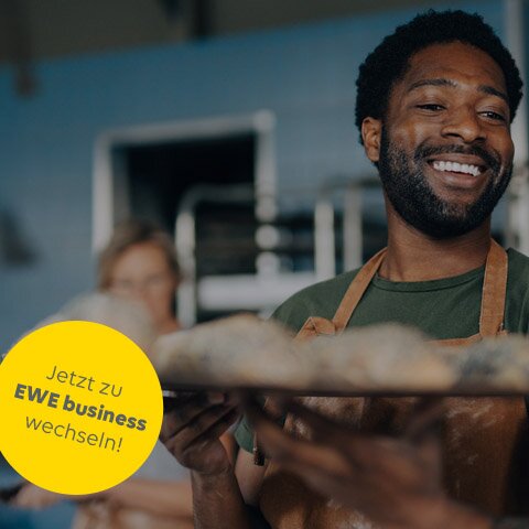 Ein Bäcker mit Tablett in der Backstube