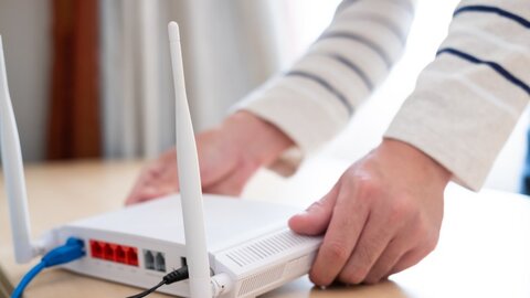 Ein WLAN-Gerät, das von zwei Händen hingestellt wird