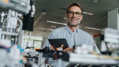 Ein Mann mit einem Tablet in einer Werkhalle