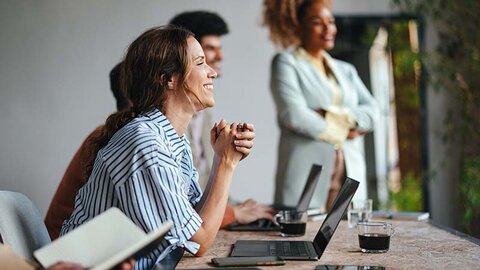 Mythen über Glasfaser Mehrere Personen im casual Business-Look vor Laptops