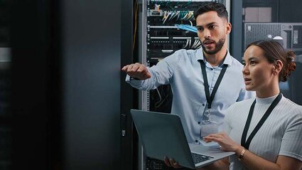 Mann und Frau mit einem Laptop in einem Serverraum