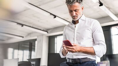 Mann im weißen Hemd am Handy