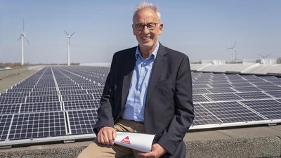 Mann mit Brille vor PV-Anlage