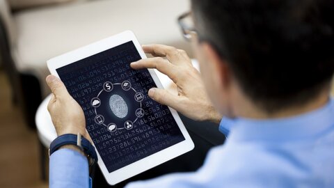 Ein Mann entriegelt sein Tablet per Fingerprint