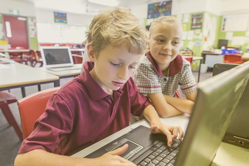 Junge und Mädchen sitzen gemeinsam vor einem Laptop | EWE macht Schule