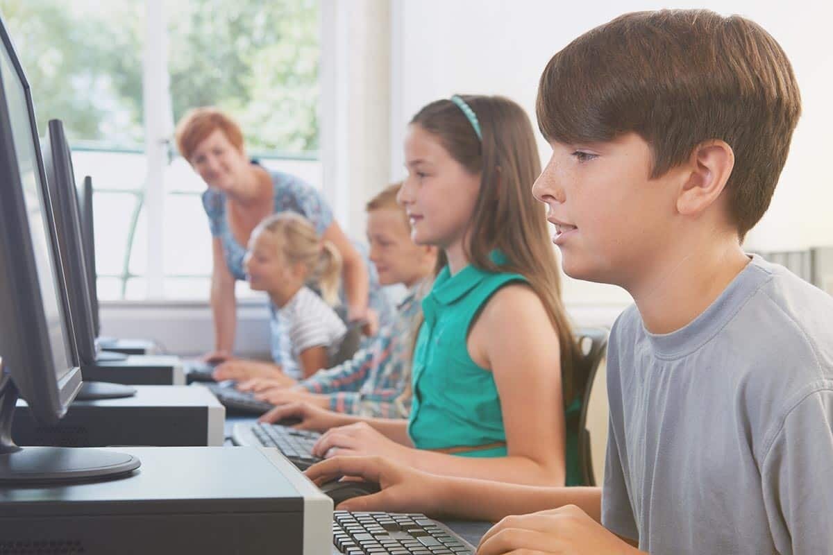 Schüler sitzen in der Schule vor PCs und lernen gemeinsam | EWE macht Schule