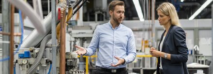 EWE business Regelenergie Eine Frau und ein Mann in einer Produktionshalle
