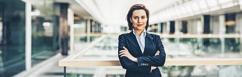 EWE business Gas logic Eine Frau in einem Unternehmensgebäude, die die Arme verschränkt