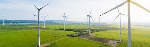 EWE Naturwatt Strom Windräder, dazwischen grüne Felder