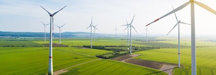 EWE Naturwatt Strom Windräder, dazwischen grüne Felder