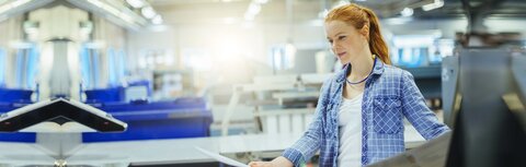 EWE business Strom logic spot Eine Frau, die einen Proof in einer Druckerei prüft