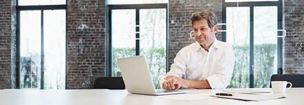 EWE Multi Connect Mann im weißen Hemd am Laptop