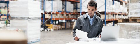 Profi-WLAN von EWE Mann in Fabrikhalle liest sich Unterlagen durch