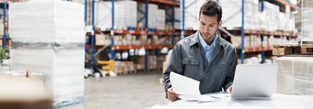 Profi-WLAN von EWE Mann in Fabrikhalle liest sich Unterlagen durch