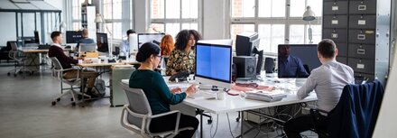 Glasfaser von EWE Mehrere Personen an Computern in Großraumbüro