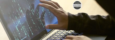 EWE DDoS-Schutz Hand eines stilisierten Hackers auf Laptop-Bildschirm