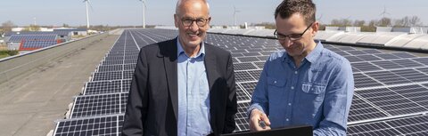 EWE business Referenz Hase Zwei Männer vor PV-Anlage
