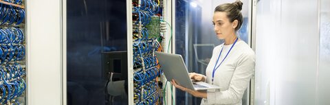 Carrier-Dienste von EWE Eine IT-Expertin mit Laptop vor einem Server