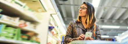 Kommunikationslösungen für den Handel Eine Frau, die in einem Markt Waren aussucht