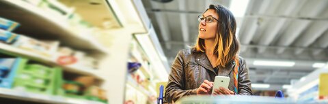 Kommunikationslösungen für den Handel Eine Frau, die in einem Markt Waren aussucht