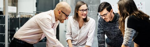 EWE business Magazin Junge Leute, die sich bei der Arbeit angeregt über ein Thema unterhalten.