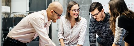 EWE business Magazin Junge Leute, die sich bei der Arbeit angeregt über ein Thema unterhalten.