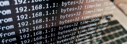 Schutz vor DDoS-Attacken Ein Bildschirm eines silbernen Laptops, auf dem Zahlen vertikal durchlaufen