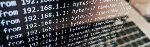 Schutz vor DDoS-Attacken Ein Bildschirm eines silbernen Laptops, auf dem Zahlen vertikal durchlaufen