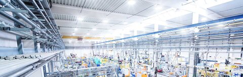 Beleuchtungsaustausch clever finanzieren Neue Industriemaschinen in einer modern beleuchteten Produktionshalle.