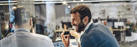 Effiziente LED-Technologie Zwei Männer unterhalten sich angeregt in einem Büro, das von LED erleuchtet wird.