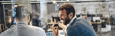 Effiziente LED-Technologie Zwei Männer unterhalten sich angeregt in einem Büro, das von LED erleuchtet wird.